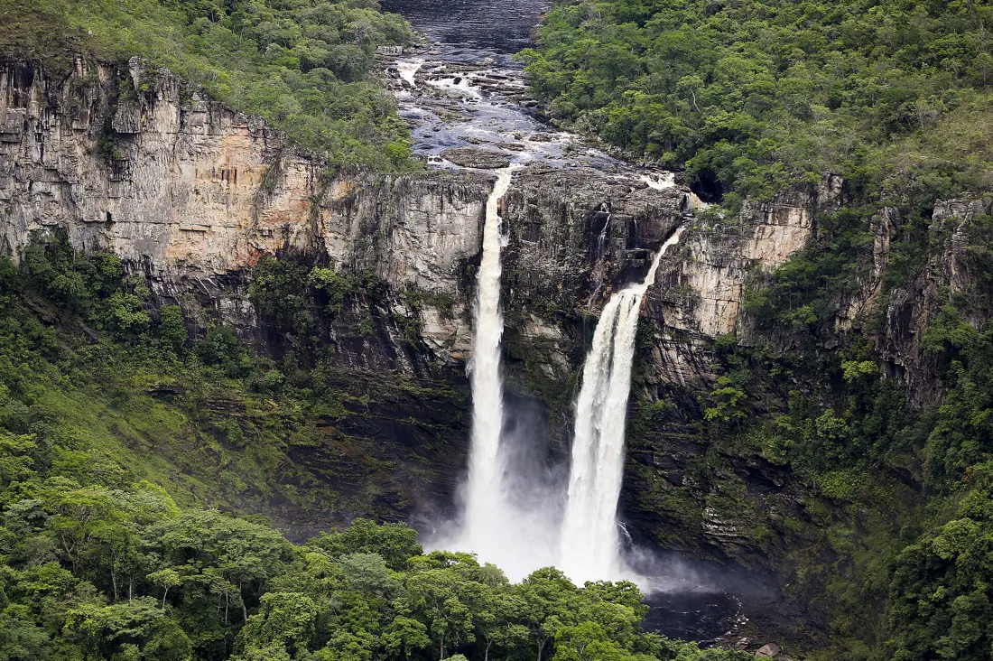 Grande cachoeira despencando entre paredões e mata na Chapada dos Veadeiros
