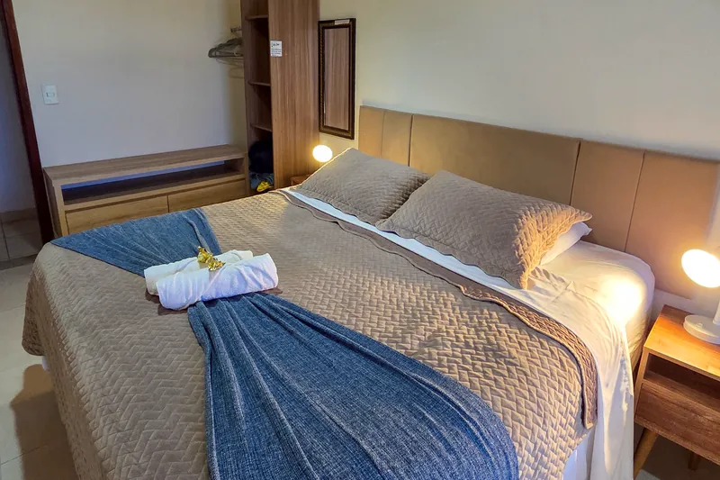 Cama de casal do Chalé Beija-flor, com abajures e armário