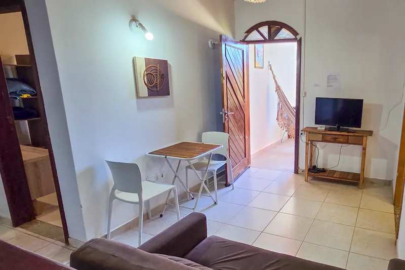 Sala do Chalé Beija-flor, com sofá, mesa e televisão