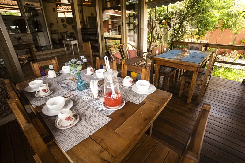 Mesa posta para o café da manhã, com o jardim ao fundo