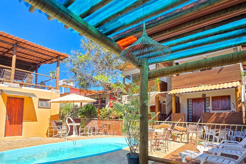Piscina da pousada, com deck de madeira e espreguiçadeiras