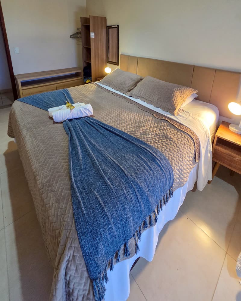 Suíte do Chalé Beija-flor com cama de casal e decoração aconchegante